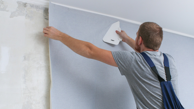 A man wallpapering