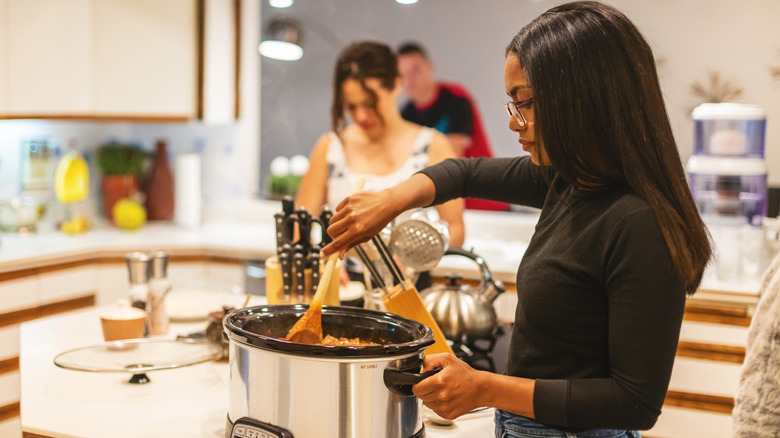 person using crockpot