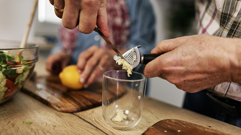 hands using a garlic press