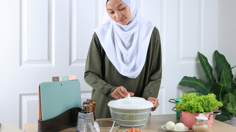 person using salad spinner