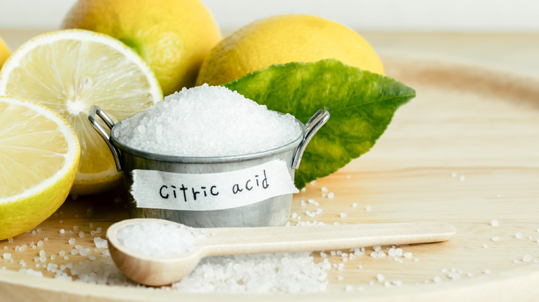citric acid in a metal tin next to lemons