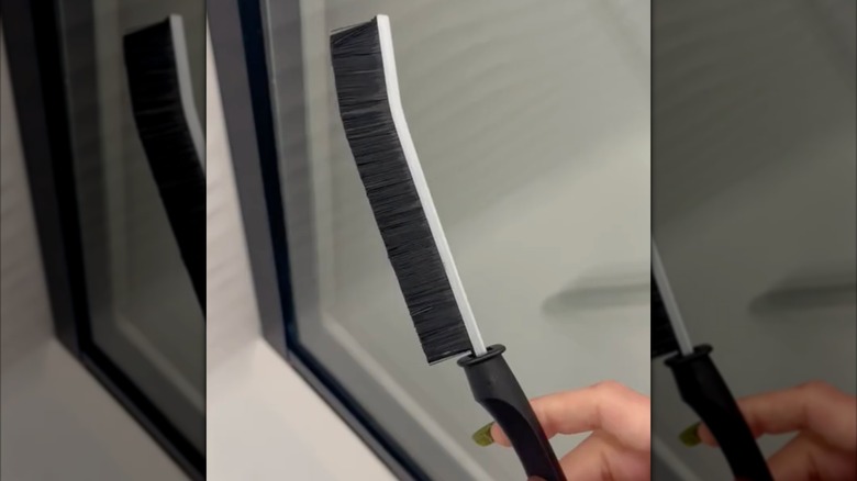 screenshot from video showing long and skinny brush with black bristles