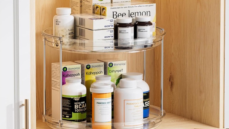 Plastic lazy Susan in cabinet with medicine bottles and boxes on it