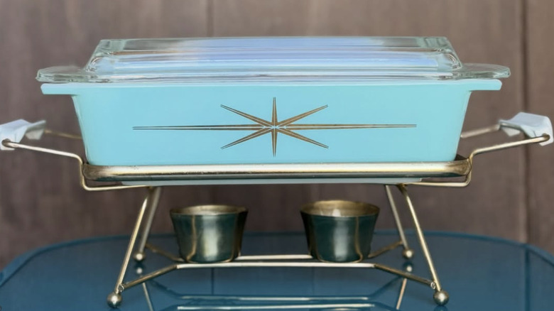 A Pyrex starburst casserole with a stand and warmer