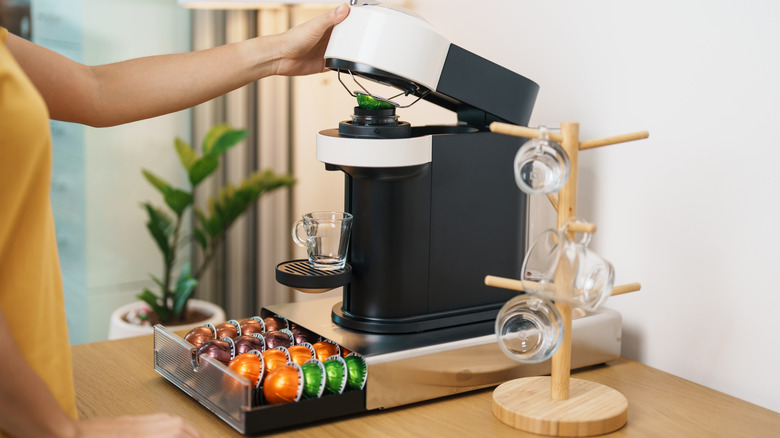 Woman holding a coffee machine open