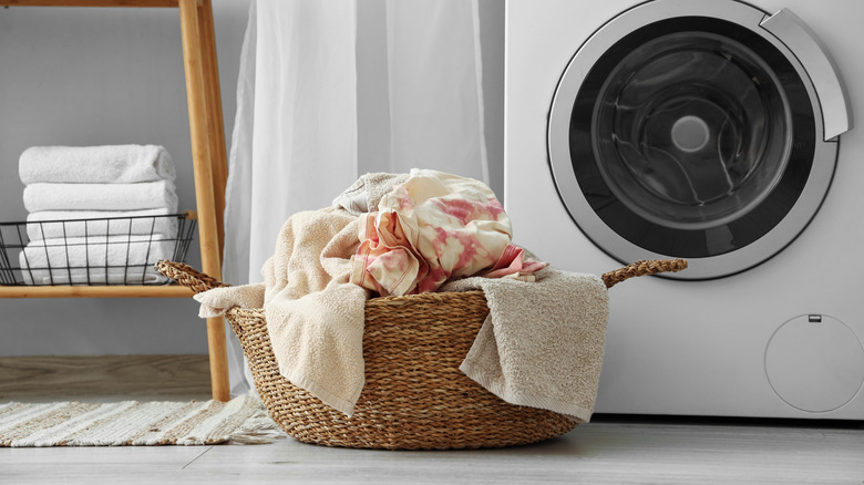 A close-up of a pile of laundry in a basket near a washing machine