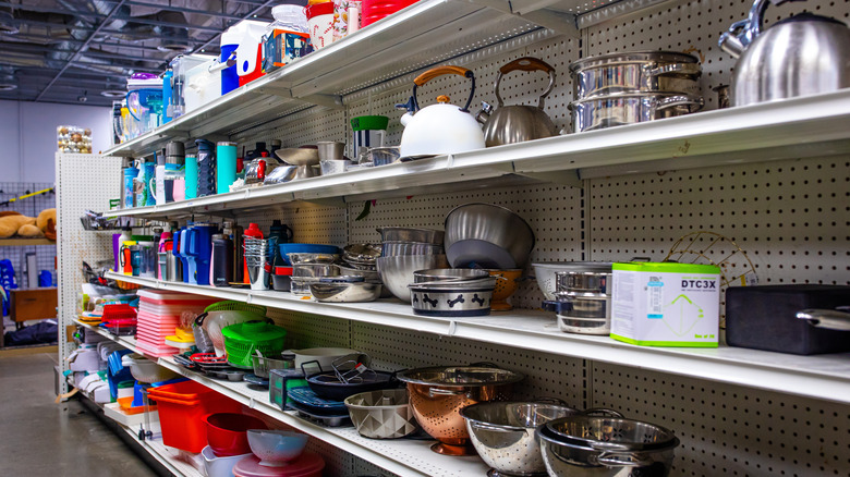 Thrift store shelves filled with kitchen items.