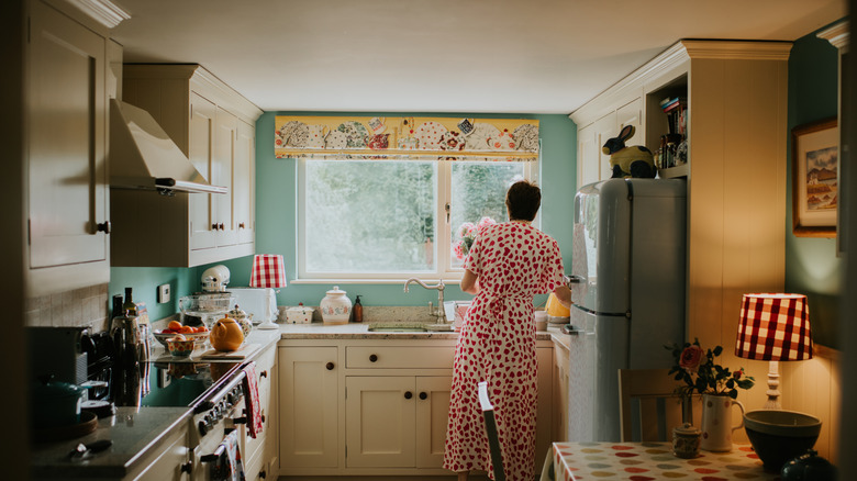 Woman doing chores in an intimate and stylish closed-concept kitchen