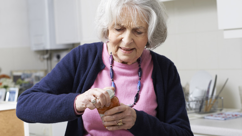 Older woman opening a jar