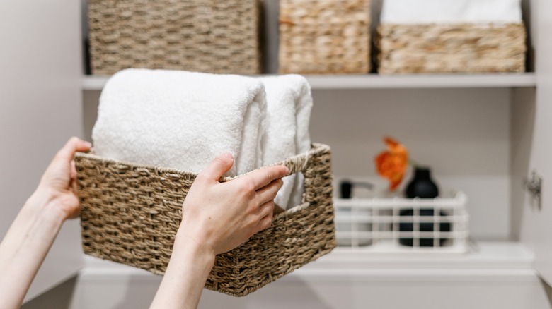 woman storing towels on shelf