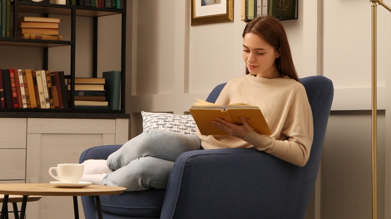 woman reading near bookshelf