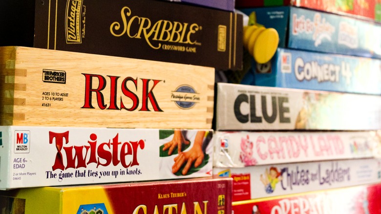 A close up of several board games, including Risk, Candyland, Clue, and Chutes and Ladders