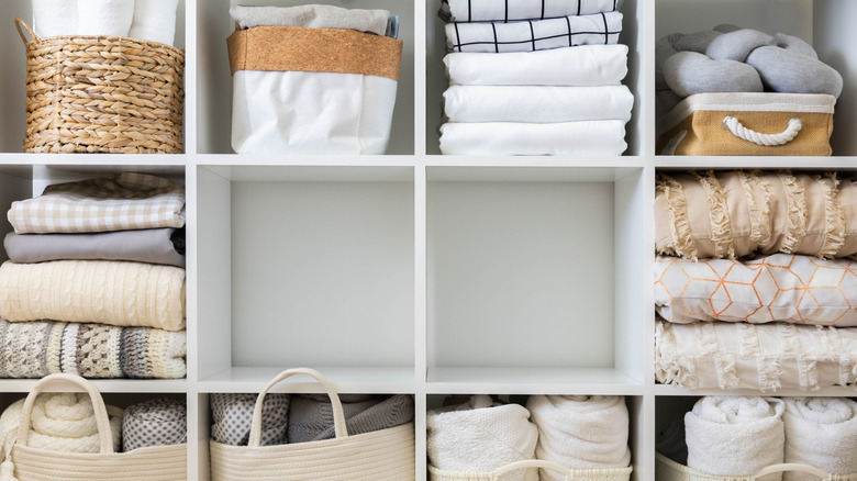 Cubicle storage closet filled with blankets and other bedding
