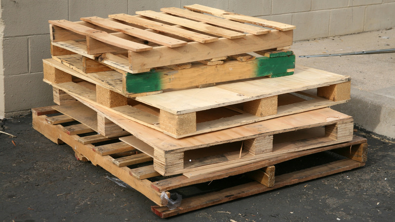 A stack of five wood pallets sitting on the ground