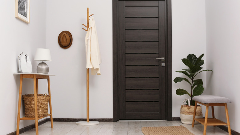 An entryway with a wooden coat rack next to the door