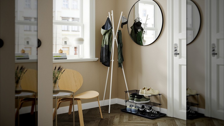The IKEA coat rack, wall mirror, and shoe rack next to a small window and door