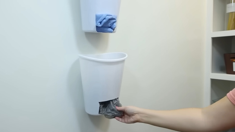 White Dollar Tree waste baskets with rectangular holes hanging on wall