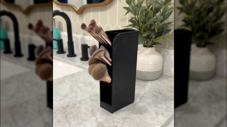 Dollar Tree pen holder used to organize makeup brushes on a bathroom counter