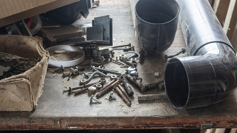 Loose screws, nuts, and bolds on a dirty workbench.