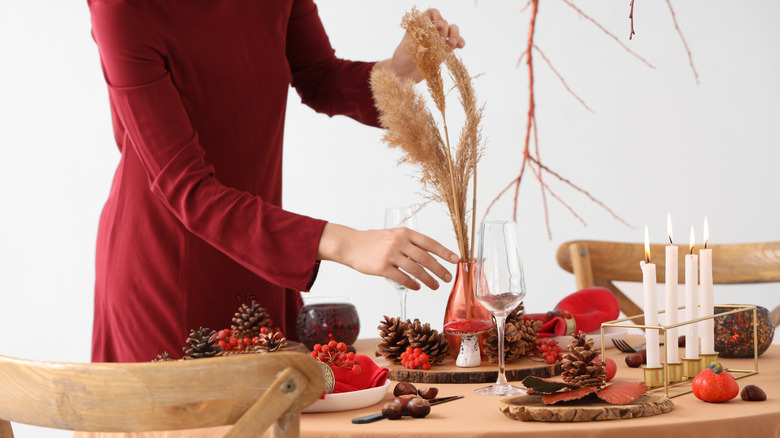 A woman decorates a table for Thanksgiving