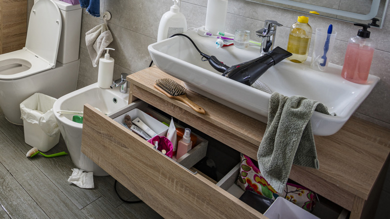 Cluttered bathroom with overflowering drawers