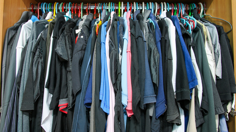 Crowded closet of shirts on hangers