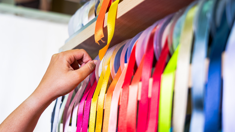 Person picking out the perfect color ribbon to personalize their DIY rustic jewelry organizer.