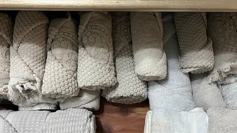 Neutral towels rolled up and in a drawer