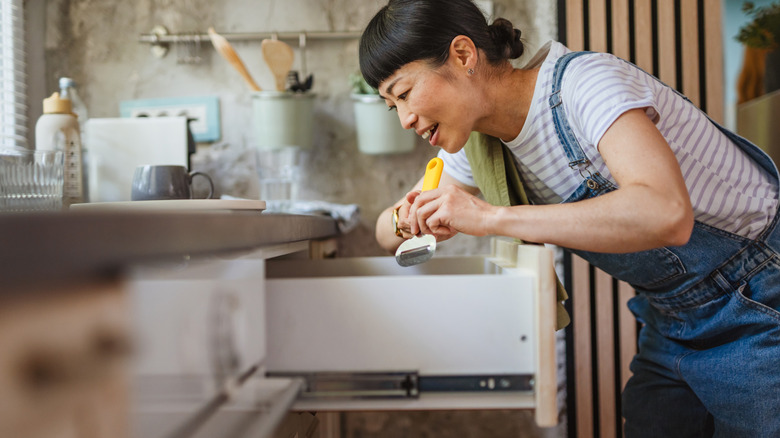 Woman organizing her kitchen holding item