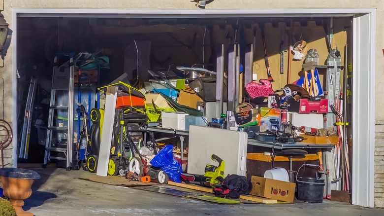 A messy garage with an open door.