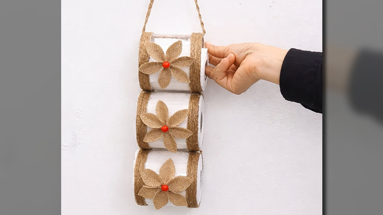 Completed DIY toilet paper holder with flower embellishments