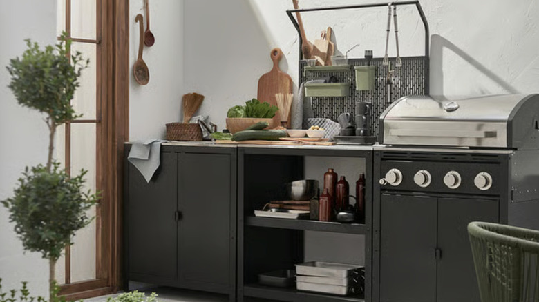 GRILLSKÄR kitchen island with back panel in between outdoor grill and cabinet.