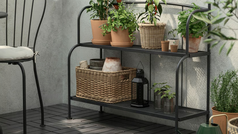 LÄCKÖ shelf unit on a patio filled with potted plants.