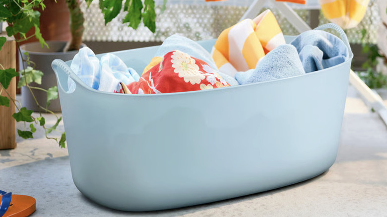 TORKIS flexible laundry basket outside, filled with pool towels.