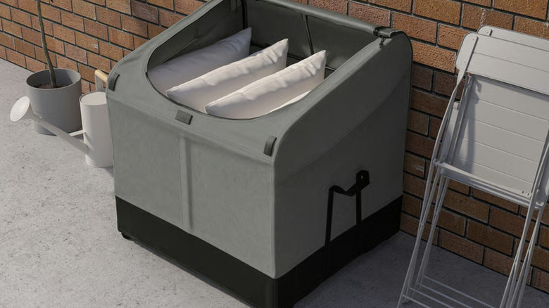 VÄTTERSÖ Storage box on a patio filled with pillows