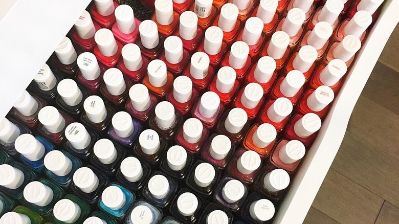An IKEA Alex drawer filled with rows of colorful nail polish bottles.