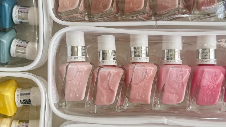 Clear travel bags filled with Essie nail polish bottles in various colors.