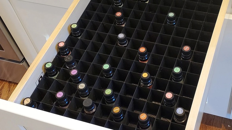 A customized drawer insert filled with bottles of nail polish.