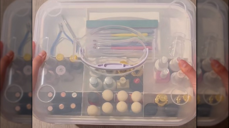 A lidded plastic storage box filled with nail essentials.