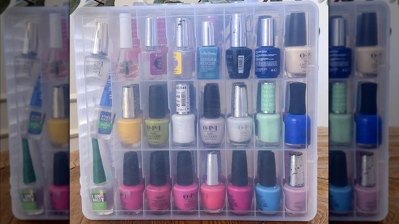 A clear plastic case filled with nail polish bottles in assorted colors.