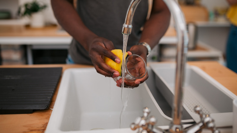 Person washing dishes in sink