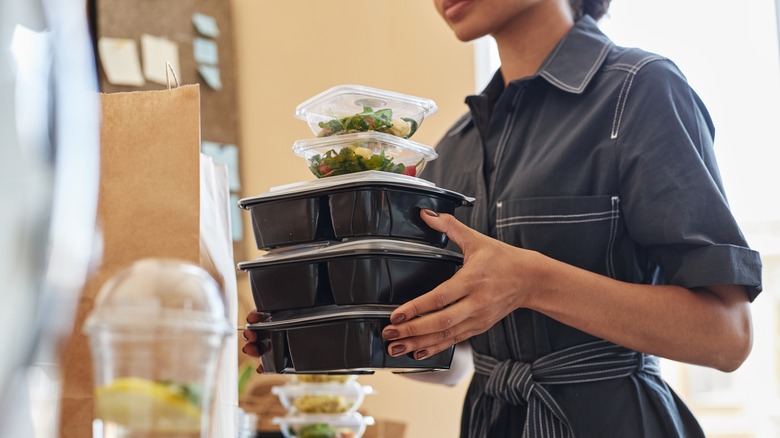 woman holding takeout containers