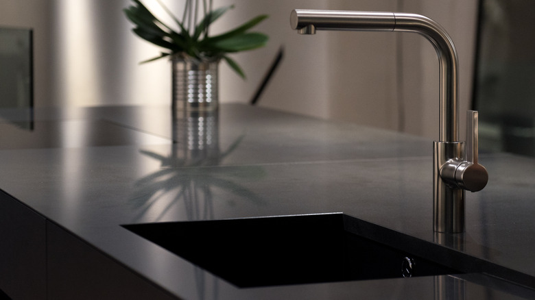 A sink with black countertops