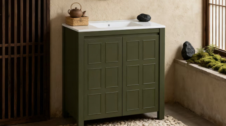 Dark green bathroom vanity in a serene-looking bathroom.