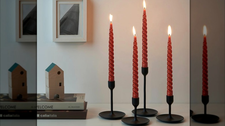 Twisted orange CONTORTATALL unscented chandelier candles in holders