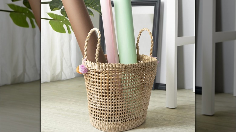 A woven IKEA MÄVINN basket holding yoga mats