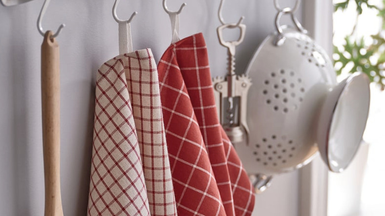 Red patterned IKEA RINNIG dish towels hanging from hooks
