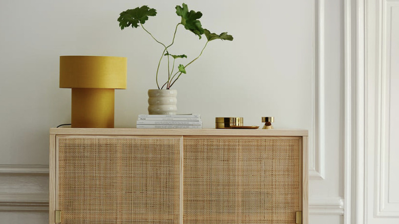 A yellow IKEA STOCKHOLM lamp sitting on an entryway table