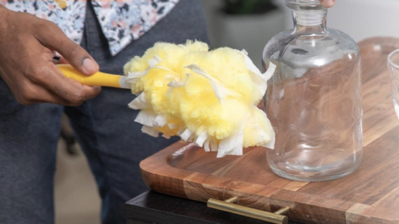Person using Swiffer Duster Heavy Duty Duster to clean vase