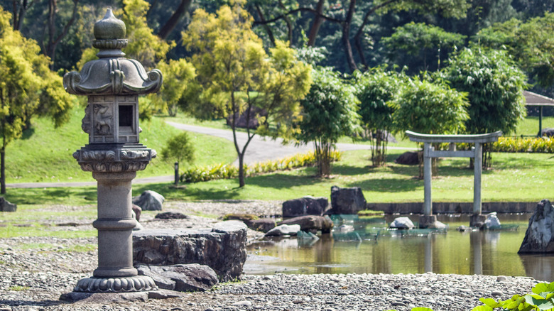 A Japanese style garden with gravel walkways and a pond